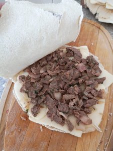 Agrega encima del queso la carne preparada. Cierra el pan árabe (pan pita) y ponlo en la sartén hasta que dore un poco por ambos lados y el queso haya derretido.