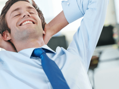 profesional sonriendo en su espacio de trabajo, representando la felicidad laboral y el bienestar emocional.