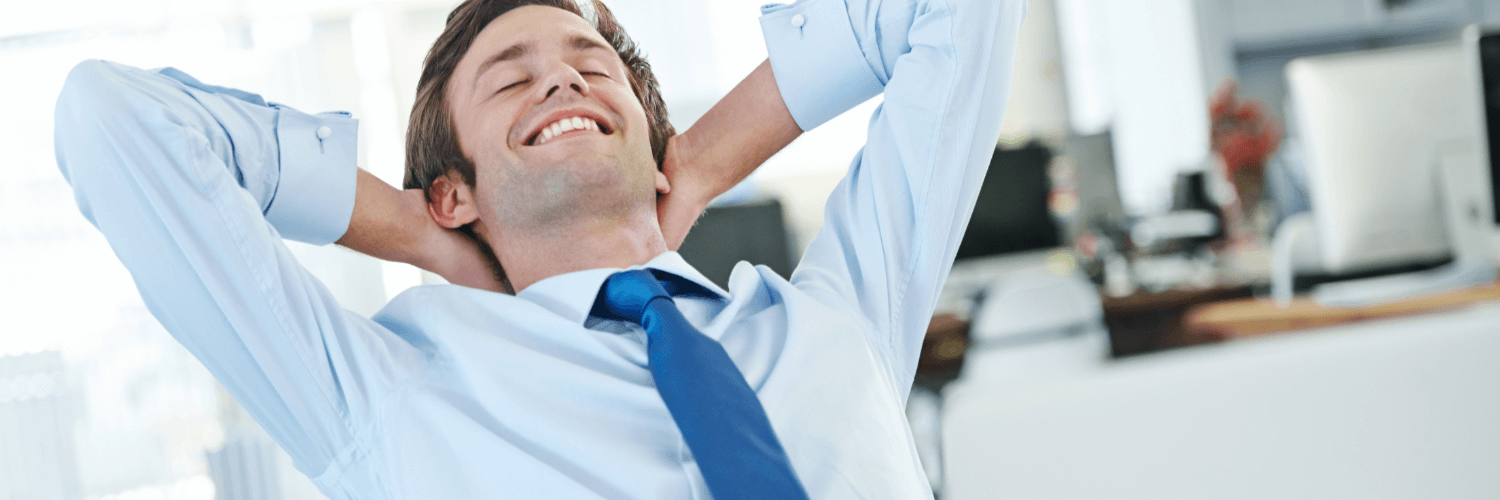 profesional sonriendo en su espacio de trabajo, representando la felicidad laboral y el bienestar emocional.